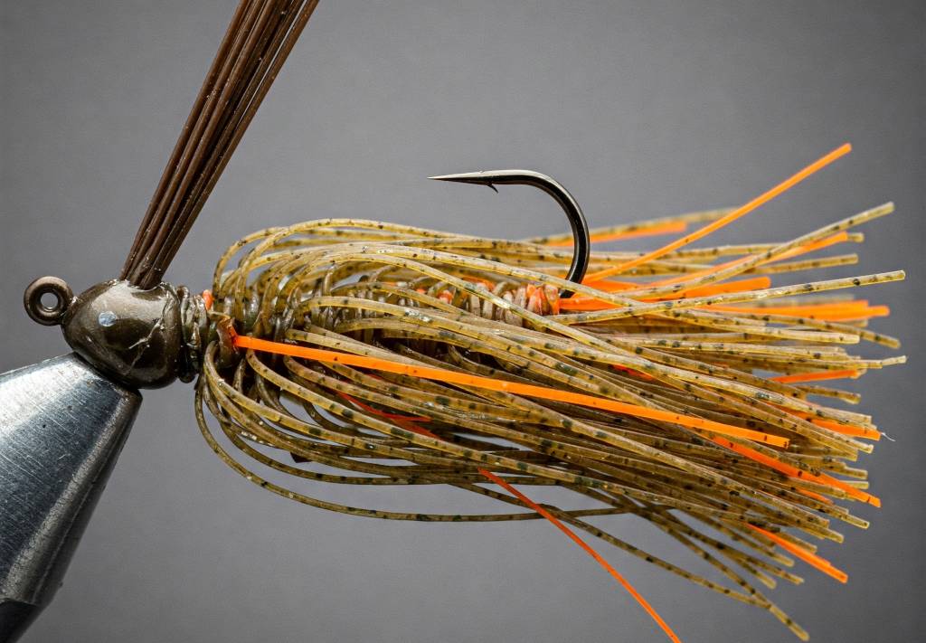 Close-up image of a custom fishing jig featuring the Easy Kasting Missouri Craw skirt pattern, built with layered Green Pumpkin (dominant), Brown, and Electric Orange silicone tabs for a realistic crawfish look.