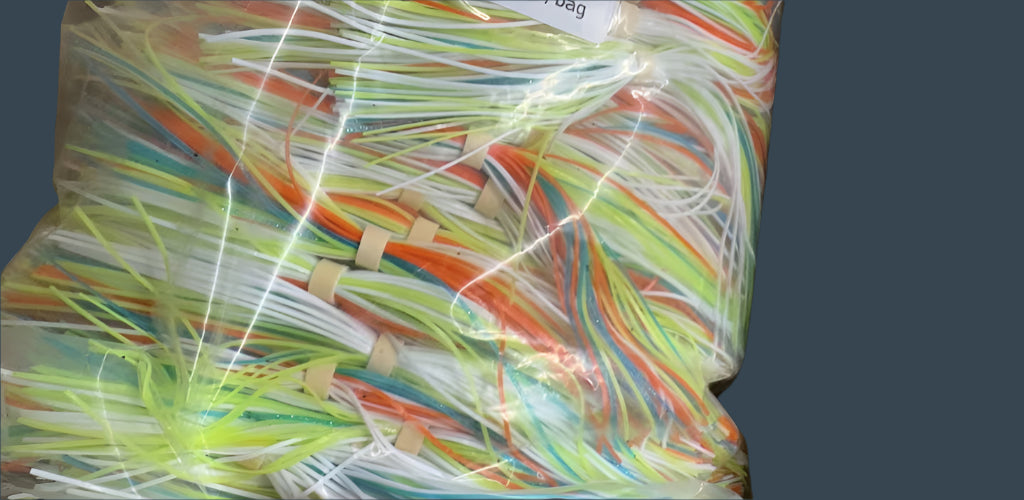 Pack of 25 pre-banded Sunburst Blend (green, orange, white, chartreuse) silicone jig skirts with 60 strands.